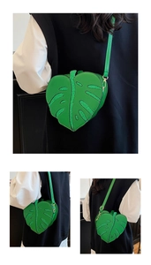 Close-up of leaf-shaped crossbody bag with vibrant green glitter details and gold hardware