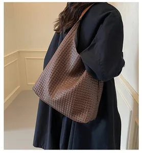 Close-up of brown woven tote bag showing fine faux leather texture and hobo shoulder design