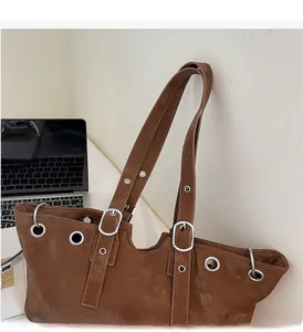 Detail of adjustable straps and silver metal eyelets on vintage brown suede tote bag
