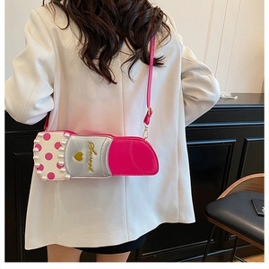 Vue détaillée d'un sac bandoulière rose en forme de rouge à lèvres avec perles et broderie