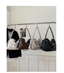 Detail of four retro tote bags in various colors hanging with textured leather finishes