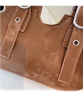 Close-up of vintage brown tote bag with matte texture, stitching, and metal eyelets