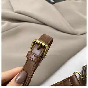 Detail of dark brown leather strap with vintage brass buckle and fine stitching