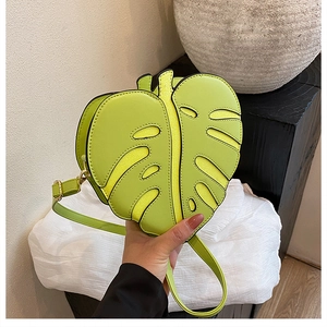 Detailed view of leaf-shaped PU leather crossbody bag in vibrant lemon green with stitching
