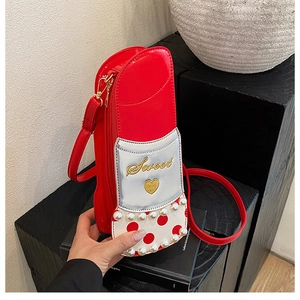 Détail du sac à bandoulière rouge en forme de rouge à lèvres avec perles et broderie