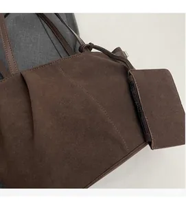 Close-up of dark brown suede tote bag featuring fine stitching and a detachable coin purse