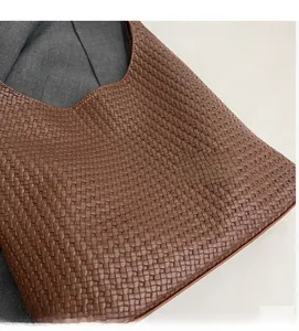 Detailed view of brown woven checkerboard leather tote with soft texture and pattern