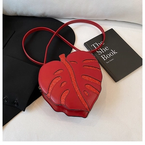 Detail of red leaf-shaped shoulder bag with glitter texture and smooth faux leather