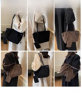 Detail of suede shoulder tote bag in black and brown with matching mini pouch attachment