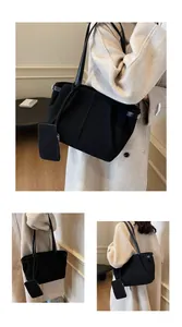 Close-up of black suede tote bag with matching coin purse and minimalist stitching