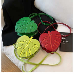 Detail showing monstera leaf shaped crossbody bags with glitter texture and metallic clips