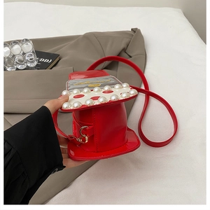 Détail du sac à bandoulière rouge en forme de chapeau avec perles et motif à pois