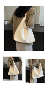Detail of woven texture and premium leather strap on this large beige hobo tote bag