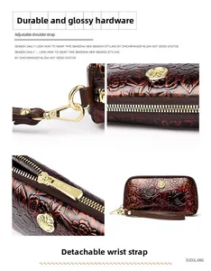 Detail view of the floral embossed leather wallet with golden hardware and wrist strap