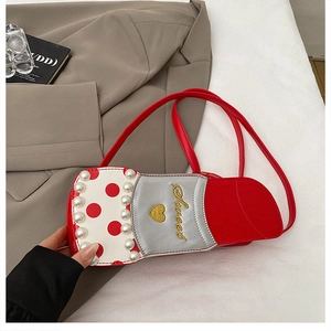 Détail d'un sac bandoulière créatif en forme de rouge à lèvres avec perles et broderie