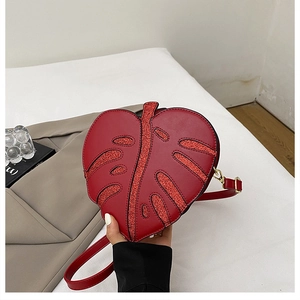 Close-up of a red leaf-shaped crossbody bag featuring shimmering sequin vein details
