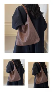 Detail of deep brown woven leather tote bag showing intricate crisscross texture