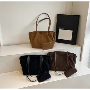 Detailed set of suede tote bags in brown, coffee, and black on minimalist white stairs