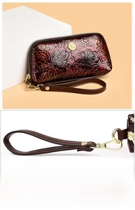 Close-up of vintage embossed floral leather clutch with wrist strap and metal detail