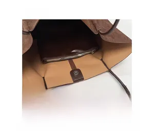 Interior view of brown suede tote bag featuring beige leather lining and magnetic closure