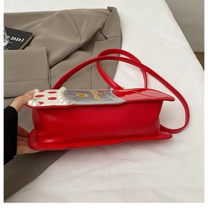 Détail du sac rouge à bandoulière avec accents de perles, logo cœur et broderie Sweet