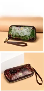 Detail of floral embossed texture on a retro green and red zip clutch wristlet bag
