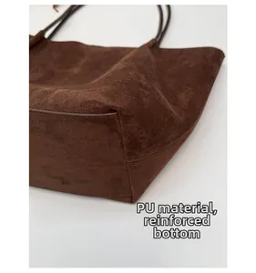 Close-up of the reinforced thickened bottom and premium PU leather texture on a tote bag