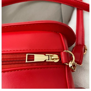 Vue macro de la texture du cuir rouge avec fermeture éclair dorée et détails de la sacoche