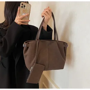 Detail of coffee brown suede tote bag with matching zipper pouch and silver buckle