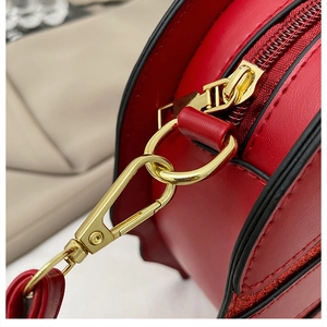 Detail view of red maple leaf bag with lychee grain leather and golden hardware zip