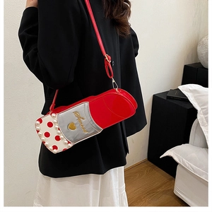 Détail d'un sac bandoulière rouge en forme de rouge à lèvres avec perles et broderie Sweet