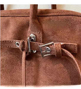 Detail of vintage brown suede Boston bag with premium silver hardware and leather strap