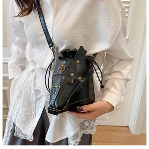 Detailed view of the horse head shaped bucket bag with gold rivets and leather strap