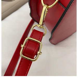 Close-up of red PU leather bag with golden adjustable strap buckle and metal hook