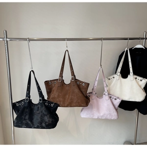 Detailansicht von vier Vintage-Tragetaschen in Schwarz, Braun, Beige und Lila mit Ösenverzierung
