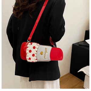 Détail du sac bandoulière rouge en forme de rouge à lèvres avec perles et broderie