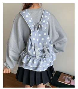 Detail of blue polka dot backpack with ruffled trim and adjustable grey buckle straps