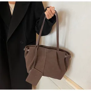 Detail of brown suede tote bag with side buckle and matching small hanging pouch