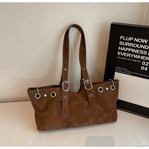 Detail view of vintage brown suede tote bag with metallic grommets and decorative buckle
