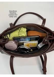 Macro top view of the spacious inner compartment of the brown faux leather tote bag