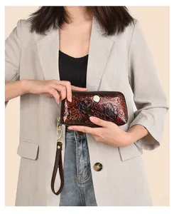 Detailed close-up of retro floral embossed leather wristlet with gold zipper