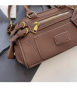 Detail of brown faux leather Boston bag with golden zipper accents and matte finish