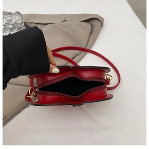 Detail view of heart-shaped red PU leather crossbody bag with double zipper and inner lining