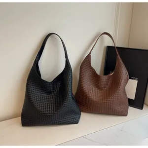 Detailed view of black and brown woven tote bags showing high-quality synthetic leather texture