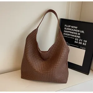 Detailed view of dark brown woven leather texture on a soft oversized hobo tote bag