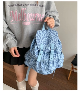 Detail of light blue polka dot backpack with adjustable straps and decorative ruffle hem