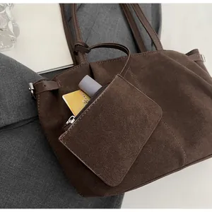 Detail of dark brown suede tote bag with matching mini pouch and metal side buckle