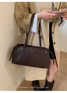 Detail view of retro brown shoulder bag with metal rings and side drawstring accents