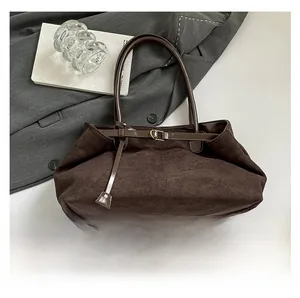 Detalle del bolso tote de ante con estampado de leopardo, correas de cuero y hebilla