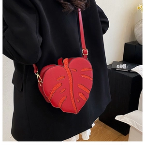 Macro detail of red leaf-shaped crossbody bag with sparkling sequins and gold hardware